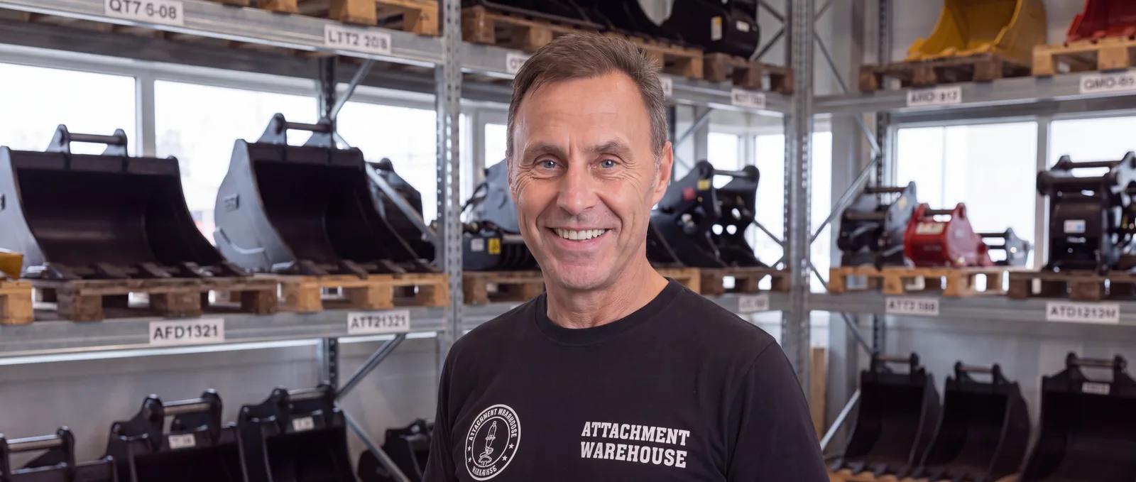 Ove from Attachment Warehouse in front of the bucket racks