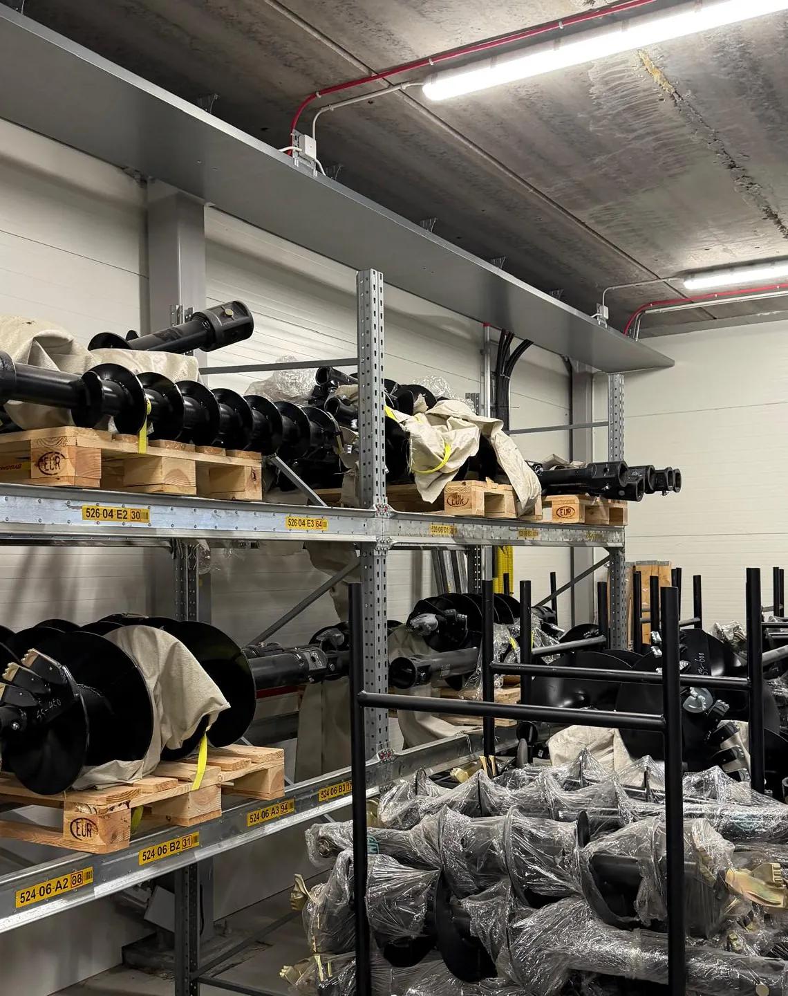 Earth augers and extension shafts on pallets and racks in our warehouse in Saltsjö-Boo